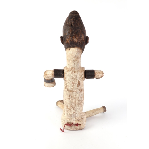 88 - A carved and painted tribal figure with articulated legs, 70cms high.