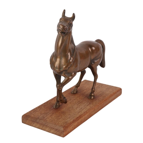 944 - A cast bronze model of a horse on a wooden plinth, 16cms long.