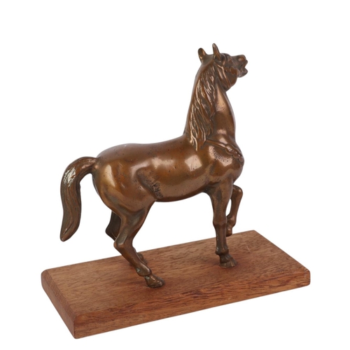 944 - A cast bronze model of a horse on a wooden plinth, 16cms long.