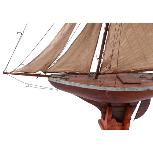 796 - A large scratch built pond yacht on stand, 150cms long, 180cms high including stand.