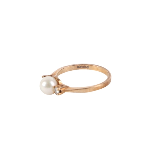 540 - A 9ct gold ring set with a central pearl flanked by two diamonds, approx UK size M, 2g.