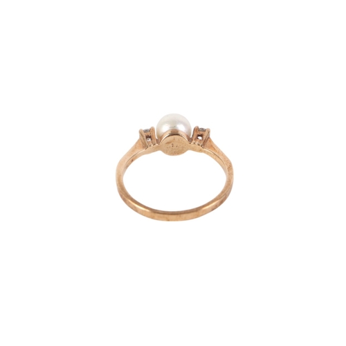 540 - A 9ct gold ring set with a central pearl flanked by two diamonds, approx UK size M, 2g.