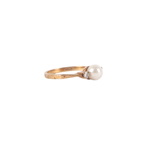 540 - A 9ct gold ring set with a central pearl flanked by two diamonds, approx UK size M, 2g.