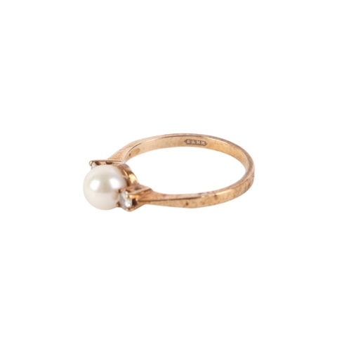 540 - A 9ct gold ring set with a central pearl flanked by two diamonds, approx UK size M, 2g.