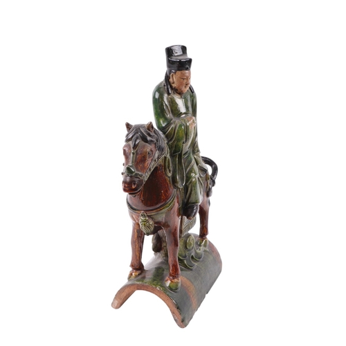 638 - A Chinese terracotta roof tile in the form of a figure on horseback, 41cms high.