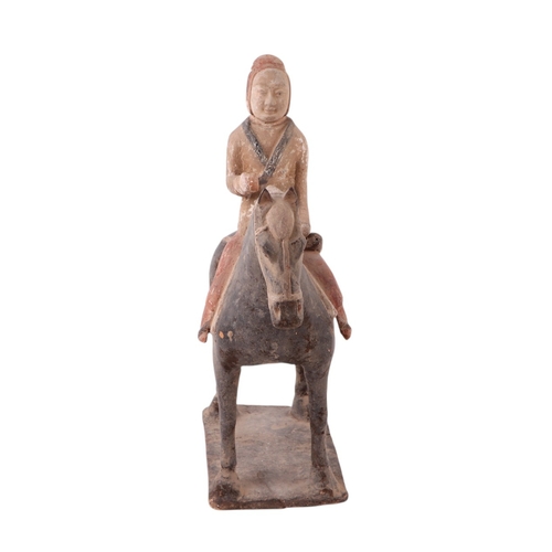 631 - A Chinese Tang Dynasty style polychrome painted terracotta model of a horse and rider, 32cms high to... 