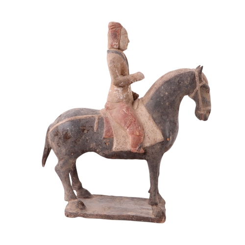 631 - A Chinese Tang Dynasty style polychrome painted terracotta model of a horse and rider, 32cms high to... 