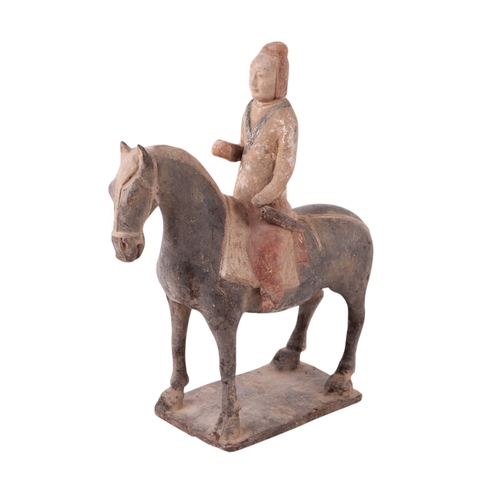 631 - A Chinese Tang Dynasty style polychrome painted terracotta model of a horse and rider, 32cms high to... 