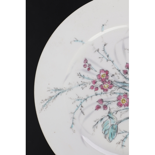 613 - A pair of Chinese famille rose plates decorated with flowers, 23cms diameter (2).