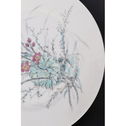 613 - A pair of Chinese famille rose plates decorated with flowers, 23cms diameter (2).