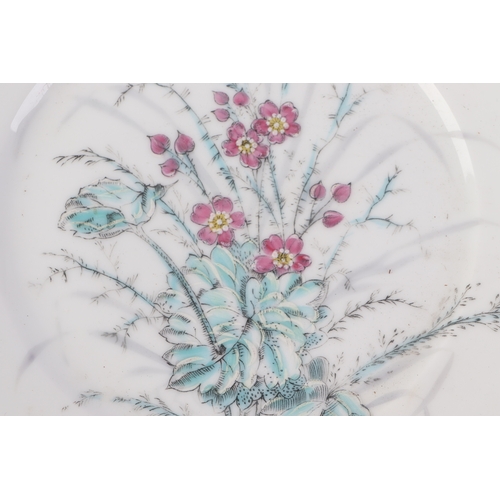 613 - A pair of Chinese famille rose plates decorated with flowers, 23cms diameter (2).