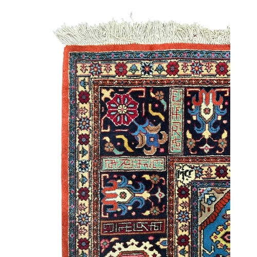 135 - A Persian Heriz woollen hand knotted carpet with stylised floral central medallion on a pink ground ... 