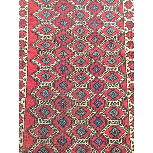 144 - A Persian Balouch woollen hand knotted rug with repeated design on a red ground, 175 by 95cms.