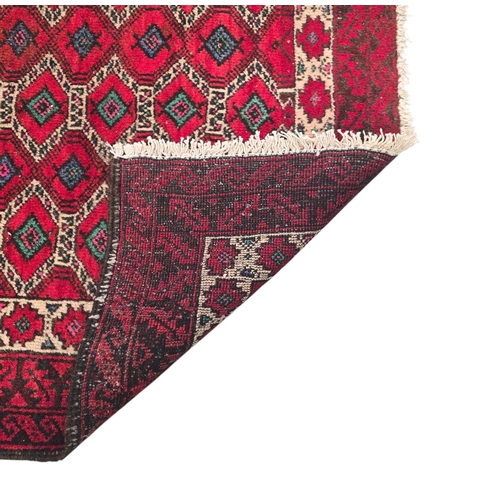 144 - A Persian Balouch woollen hand knotted rug with repeated design on a red ground, 175 by 95cms.