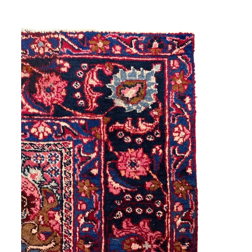 156 - A Persian Meshed woollen hand knotted rug with central floral medallion within floral borders, on a ... 