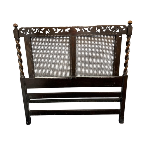 906 - A 17th century style carved oak bed frame with bergere panels, 138cms wide (3).