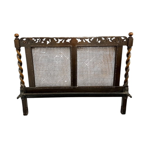 906 - A 17th century style carved oak bed frame with bergere panels, 138cms wide (3).