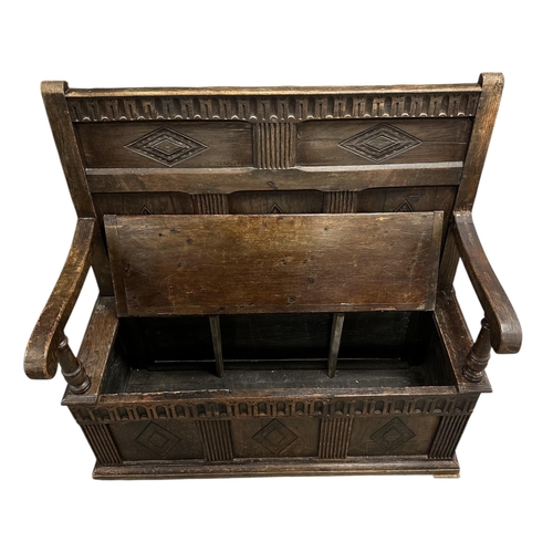 908 - A 19th century oak box settle with carved three-panelled back, scroll arms, the box section with thr... 