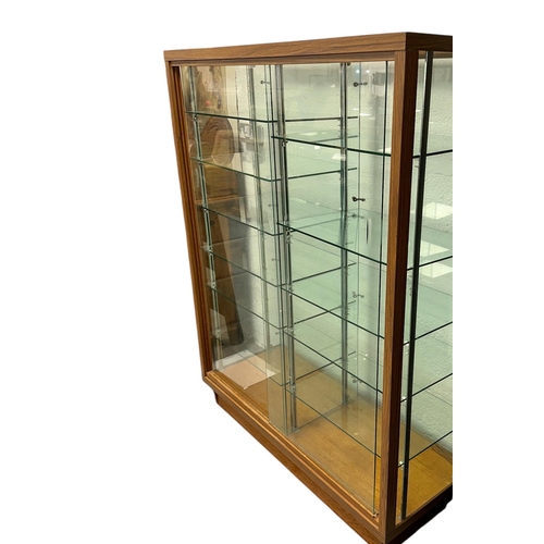 910 - A mid 20th century glass shop display cabinet with sliding doors, 108cms wide.