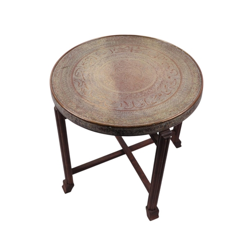 1055 - An Islamic brass topped tray table on folding stand, 60cms diameter.