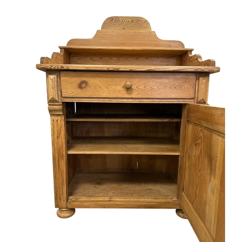 1081 - A continantal pine side cabinet, the single drawer above a field panelled door enclosing a shelved i... 