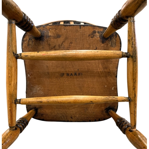 1085 - A beech and elm Windsor chair with solid seat and turned front legs joined by an H stretcher.