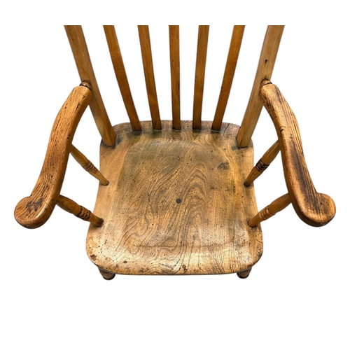 1085 - A beech and elm Windsor chair with solid seat and turned front legs joined by an H stretcher.