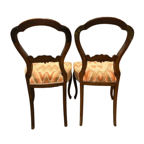 1110 - A set of six Victorian walnut balloon backed dining chairs with upholstered seats, on cabriole front... 