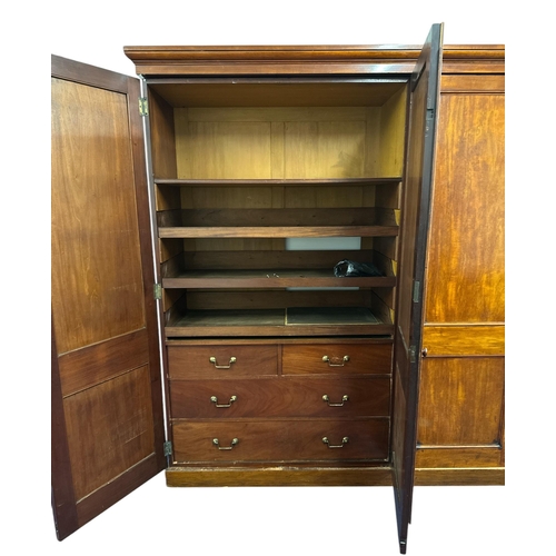 1112 - A Victorian mahogany triple wardrobe. the panelled door enclosing hanging space, linen slides and tw... 