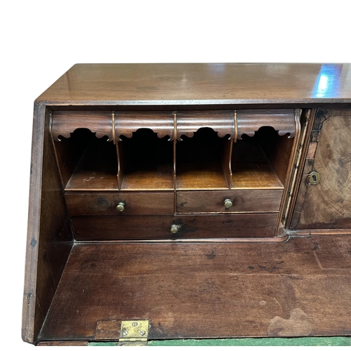 1128 - A 19th century mahogany bureau, the fall-flap enclosing a fitted interior with secret compartments, ... 