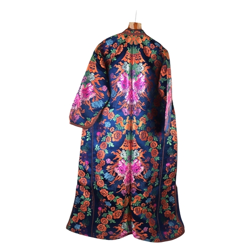 163 - A Moroccan embroidered kaftan decorated with flowers on a blue ground, signed.