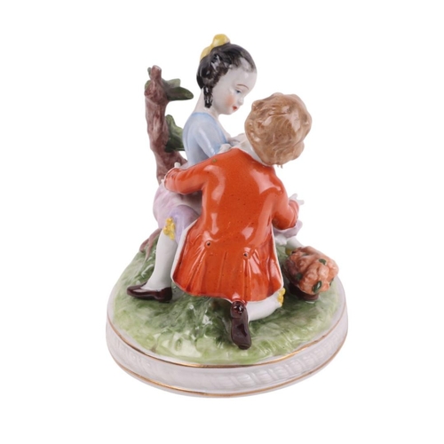 394 - A continental porcelain group depicting a young boy and a young girl with a basket of flowers, 11cms... 