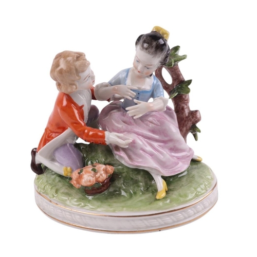 394 - A continental porcelain group depicting a young boy and a young girl with a basket of flowers, 11cms... 