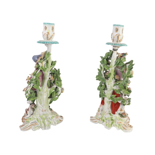 408 - A pair of porcelain figural candlesticks depicting a shepherdess and a piper, in the Derby style wit... 