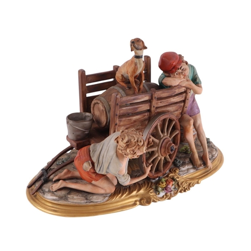 428 - A Capo di Monti figural group depicting two boys and a dog fixing the wheel on a barrel cart, 35cms ... 