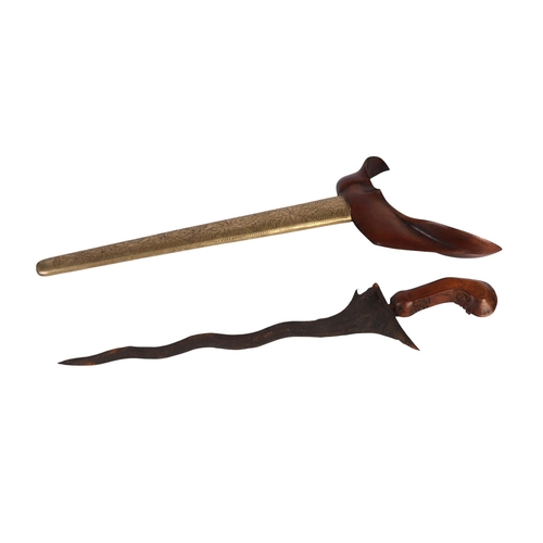 43 - An Indonesian Kris with a wavy steel blade, brass scabbard and wooden handle, 48cms long.