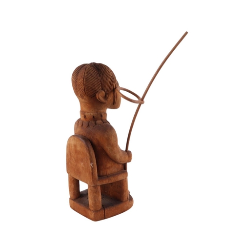 471 - African / tribal Art.  An African carved wooden figure depicting a man seated on a throne holding a ... 