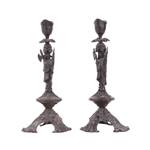 517 - A pair of late 19th century cast iron candlesticks decorated with axes and an inverted helmet; toget... 