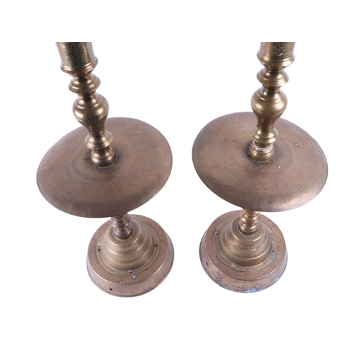 554 - A large pair of floor standing Indian brass candlesticks, 80cms high.