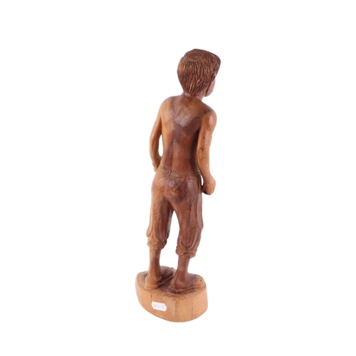 562 - A folk art wooden carving of a man with naked torso, breeches and open toed sandals, 38cms high.