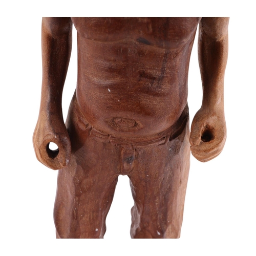 562 - A folk art wooden carving of a man with naked torso, breeches and open toed sandals, 38cms high.