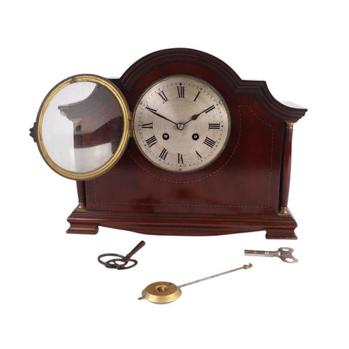 628 - An Edwardian inlaid mahogany cased mantle clock, the silver dial with Roman numerals, 32cms wide.Con... 