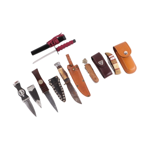 65 - A collection of pocket knives and sheath knives to include Victorinox and Rodger's.