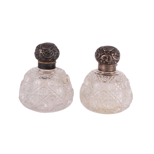 701 - A pair of Victorian hobnail cut glass scent bottles of squat globular form with silver tops, London ... 