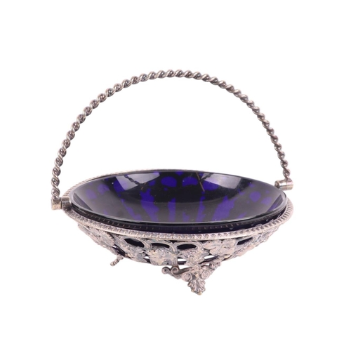 710 - A silver plated pierced basket with blue glass liner 17cms diameter.