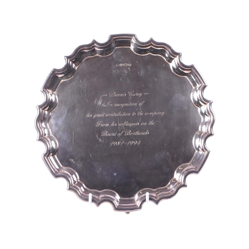 743 - A silver salver with wavy rim, on tripod feet, Sheffield 1994, engraved, 25.5cms diameter, 557g.