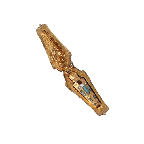 749 - An Egyptian Revival white metal and enamel sarcophagus pendant opening to reveal a gilded interior c... 