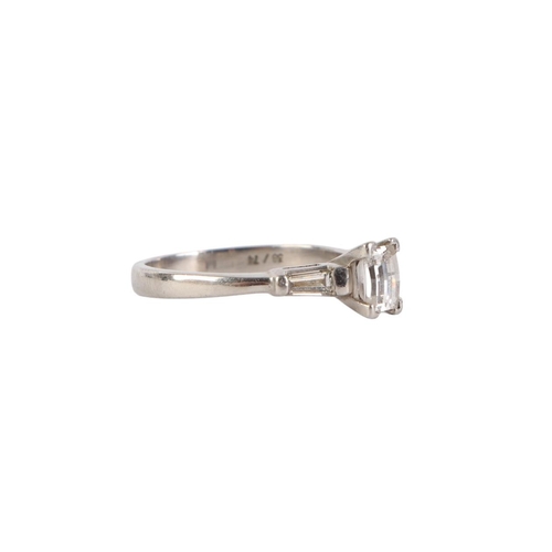 753 - A white metal (tests as 18ct gold) ring set with an emerald cut diamond and baguette cut diamond sho... 