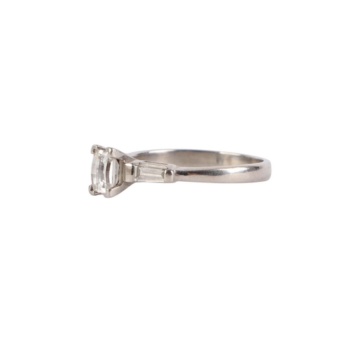 753 - A white metal (tests as 18ct gold) ring set with an emerald cut diamond and baguette cut diamond sho... 