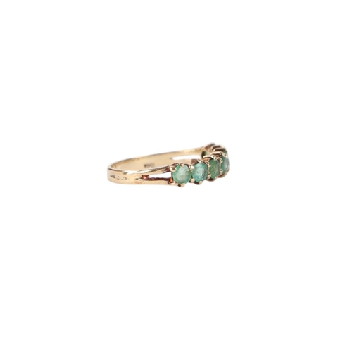 776 - A 9ct gold seven-stone emerald half eternity ring, approx UK size L, 1.3g.